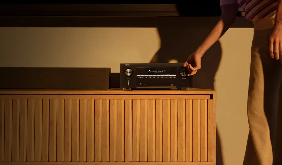 Receiver Denon AVR-X3900H sobre móvel de madeira em sala de estar